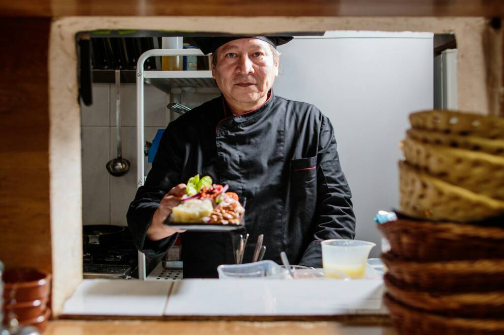 Peruvian Latinx senior chef cooking ceviche. Recipe Preparation ingredients in bistro kitchen